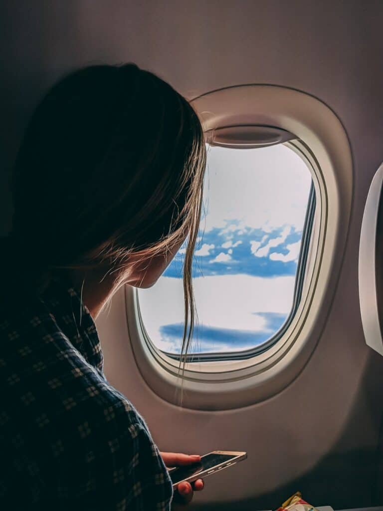 mujer mirando por la ventana de un avión